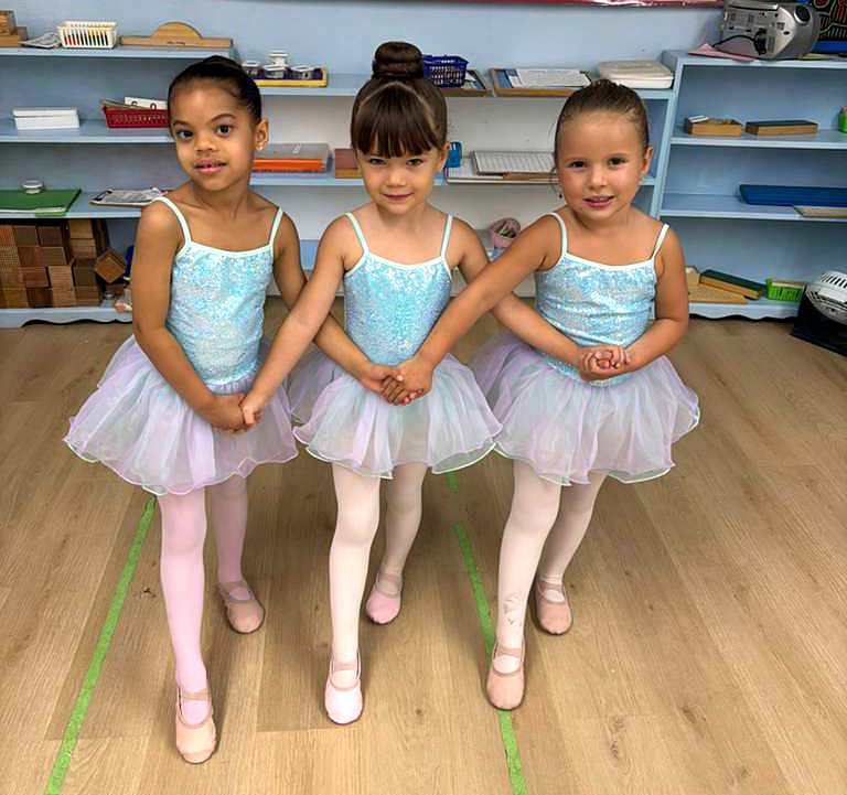 Young ballerina tying her ballet shoes with excitement