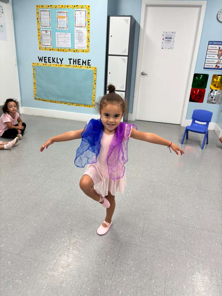 Little ballerina twirling with colorful fairy wings