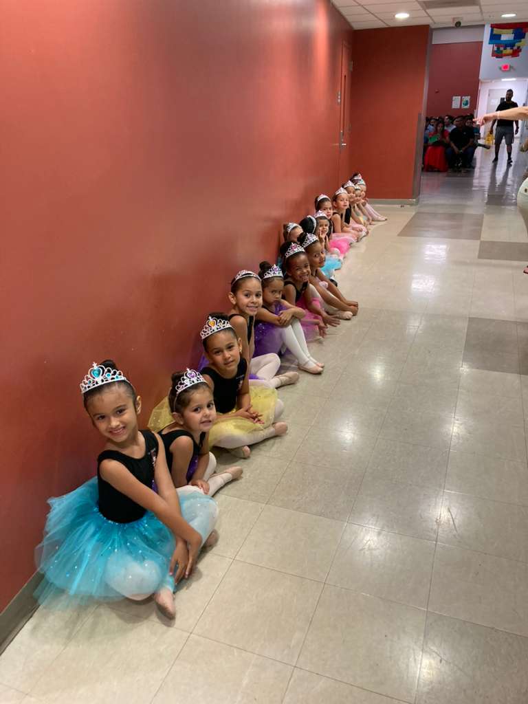 Ballerinas in tutus and tiaras lined up before performance